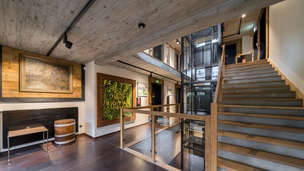 A modern interior with a wooden staircase, a glass railing, and a wooden bench. - RentPlanet - Apartament Goszczyńskiego (Zakopane)