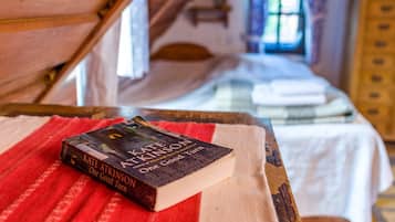 Ein Buch mit dem Titel 'One Good Turn' von Kate Atkinson auf einem Holztisch in einem Zimmer mit Bett und Fenster.