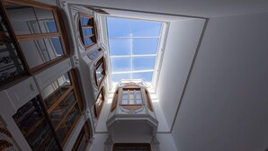 A high-ceilinged room with a skylight, ornate woodwork, and multiple windows. - Boutique Hotel Cordial Malteses (Las Palmas de Gran Canaria)