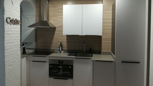 A modern kitchen with white cabinets, a built-in oven, and a sink. - YOUR PAUSE IN VALENCIA Center. July and August 10%. Discount (Valencia)