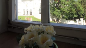 A window with a view of a cathedral and trees. - The Grich (Zagreb)