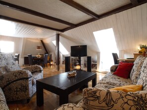 A spacious loft with high ceilings, exposed beams, and large windows. - The Grich (Zagreb)