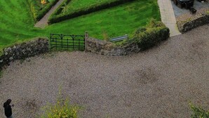 A rural landscape with a stone building, a well-manicured lawn, and a gravel path. - Unique accommodation in the centre of Bushmills - dating back to 1745  (Bushmills)