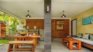 A modern living space with a dining area, kitchen, and seating area. - Coco Garden Pool Villas (Kubutambahan)