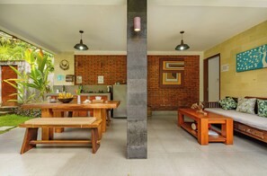 A modern living space with a dining area, kitchen, and seating area. - Coco Garden Pool Villas (Kubutambahan)
