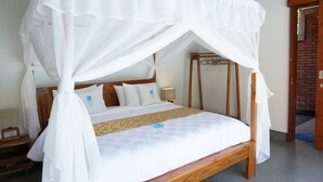 Een hemelbed met baldakijn, houten hoofdbord en een sprei met een logo.