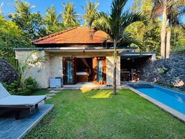 A modern house with a swimming pool, a covered patio, and a well-maintained lawn.