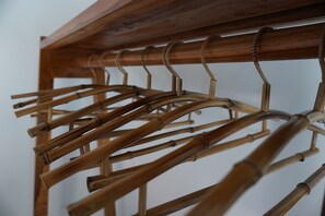 A wooden coat rack with multiple hangers. - Coco Garden Pool Villas (Kubutambahan)