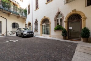 A cobblestone street with a parked car and a bicycle.