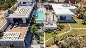 A modern multi-story building with a rooftop pool, outdoor seating, and a landscaped garden. - Villa Lydia (Kissamos)