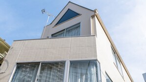 A modern building with a triangular roof, large windows, and a visible antenna. - ILIMA Higashi Nakano (Tokyo)