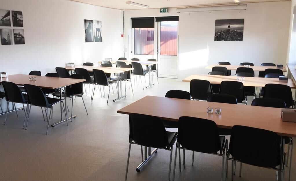 A classroom with multiple tables and chairs arranged for group activities.