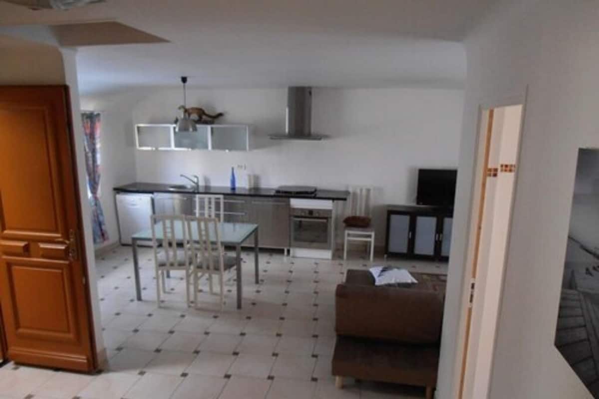 A compact living space with a kitchenette, a dining area, and a seating area.
