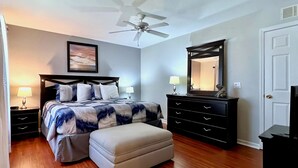 A bedroom with a bed, a nightstand, a dresser, a mirror, a ceiling fan, and a door. - EPIC VALUE! Disney Retreat! Peter Pan! Resort! (Davenport)