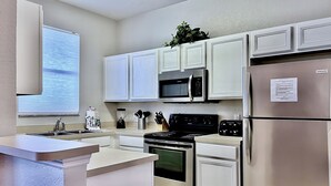 A modern kitchen with white cabinetry, stainless steel appliances, and a built-in microwave. - EPIC VALUE! Disney Retreat! Peter Pan! Resort! (Davenport)