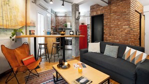 Ein modernes Wohnzimmer mit Küche, Essbereich und einer Sitzecke mit Sofa und Sesseln.