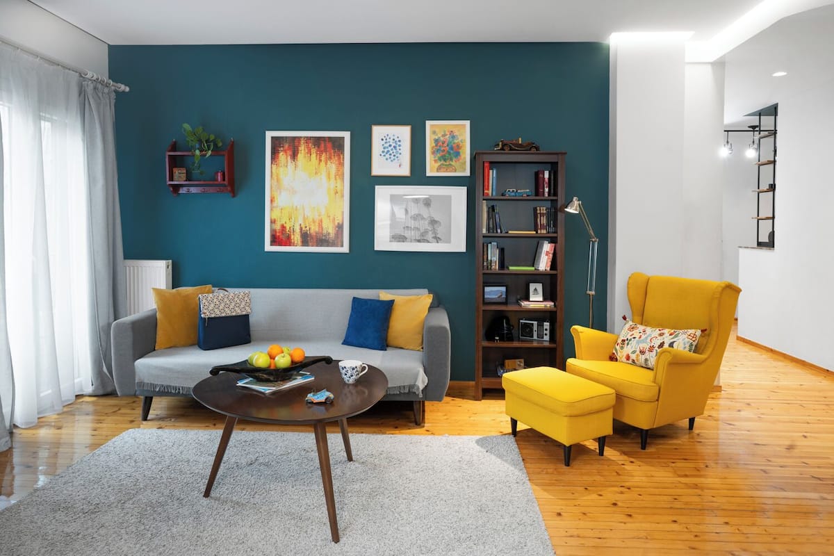 Un salon comprenant un canapé, un fauteuil, une table basse et une bibliothèque.