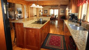 A spacious kitchen with granite countertops, wooden cabinets, and a central island. - Luxury Mountain Cabin w/ Hot Tub 75 Private Acres, & Near New River (Jefferson)