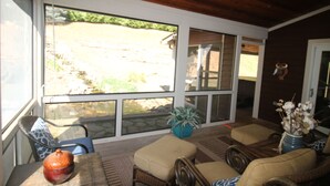 A sunlit room with wicker furniture, large windows, and a view of a backyard. - Luxury Mountain Cabin w/ Hot Tub 75 Private Acres, & Near New River (Jefferson)