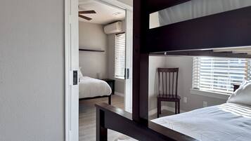 2 habitaciones, escritorio y tabla de planchar con plancha