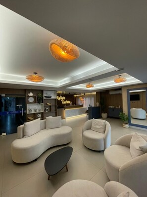 A modern living room with sofas, a coffee table, and pendant lighting. - Pousada Refúgio Costeiro (Bombinhas)