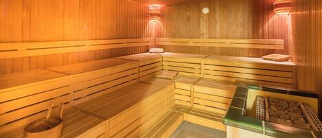 En sauna med træbænke og en stenbasseng.