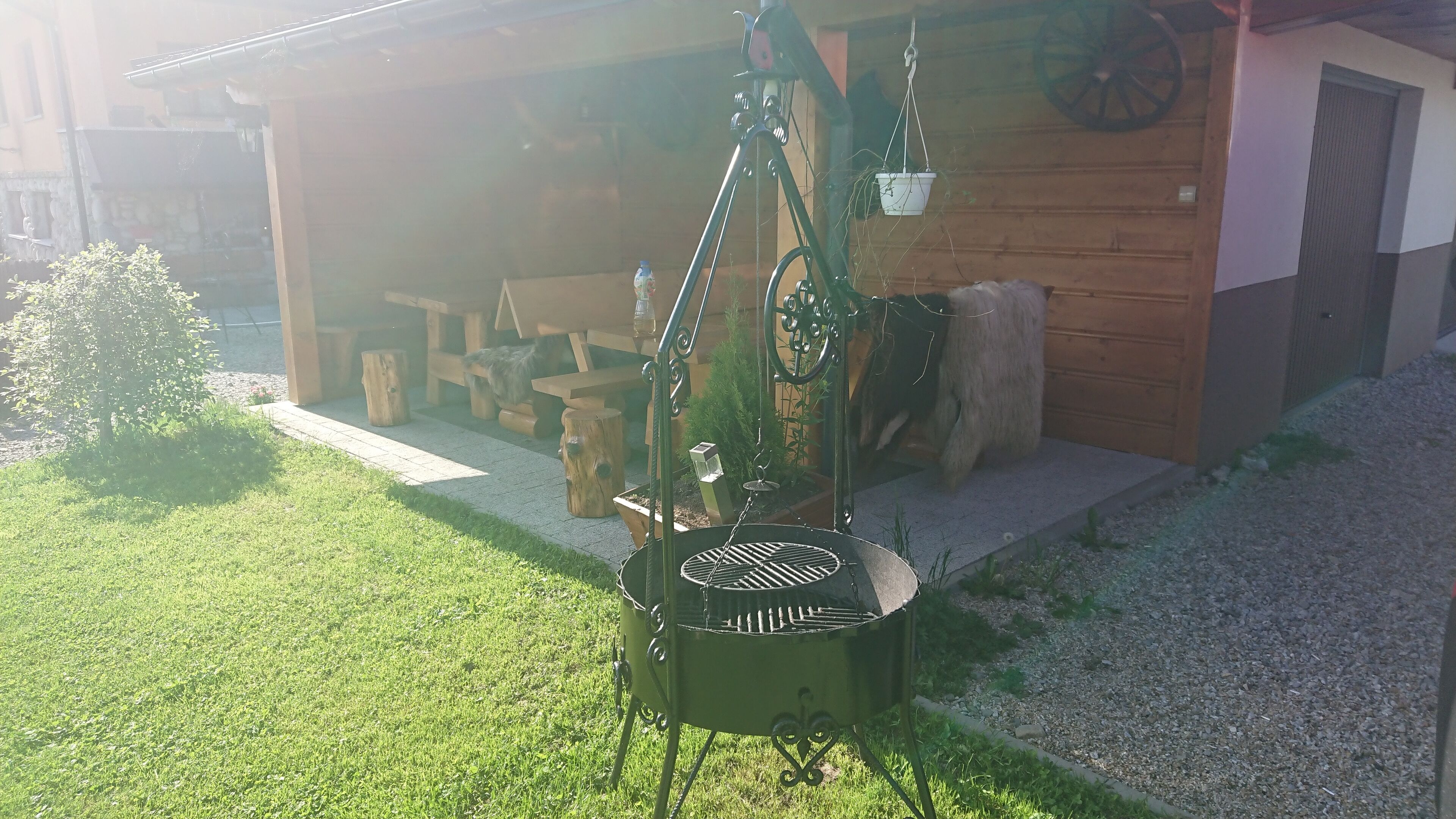 A barbecue grill outdoors with a wooden building in the background.