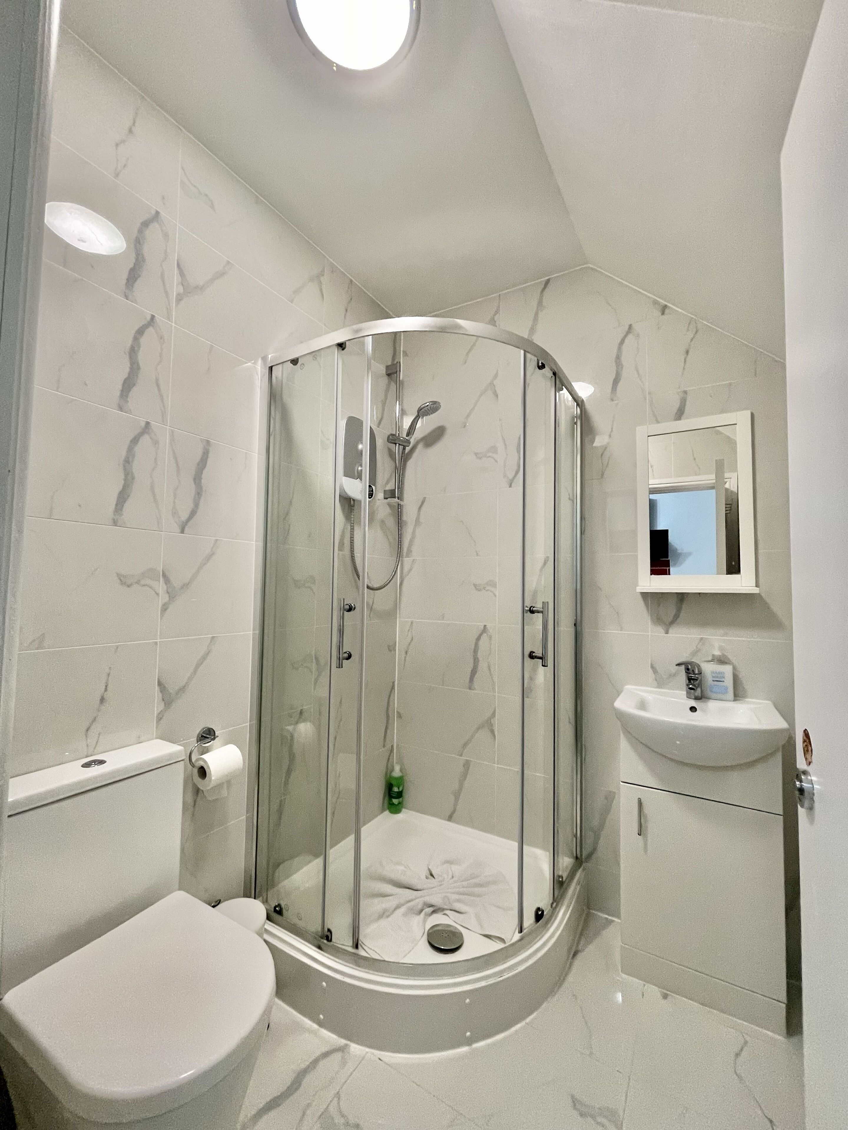 Une salle de bain moderne avec une douche à parois de verre, des toilettes et un lavabo.