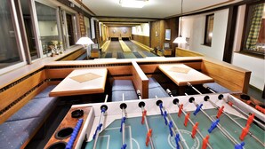 A corridor with a foosball table and seating areas. - Hotel Vanda (Irschen)