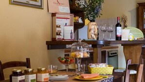 Una mesa de comedor con comida, vino y salsas.