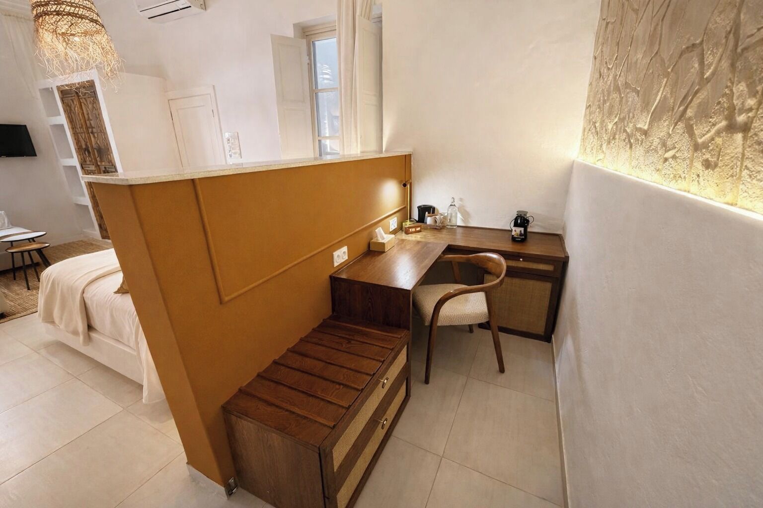 Une petite pièce comprenant un lit, un bureau en bois et une chaise.