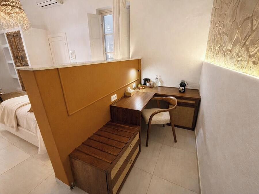 Une petite pièce comprenant un lit, un bureau en bois et une chaise.