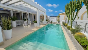 Una piscina al aire libre, tumbonas