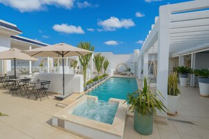 Una piscina al aire libre, sillones reclinables de piscina