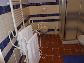 Une salle de bain avec une baignoire blanche, des toilettes blanches et un espace douche.