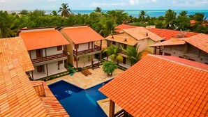 A resort with multiple buildings, a swimming pool, and a view of the ocean. - Pousada Recanto do Mar (Camocim)