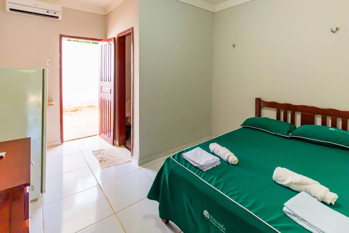 Una habitación de hotel con una cama, un escritorio y una puerta que da a un pasillo.
