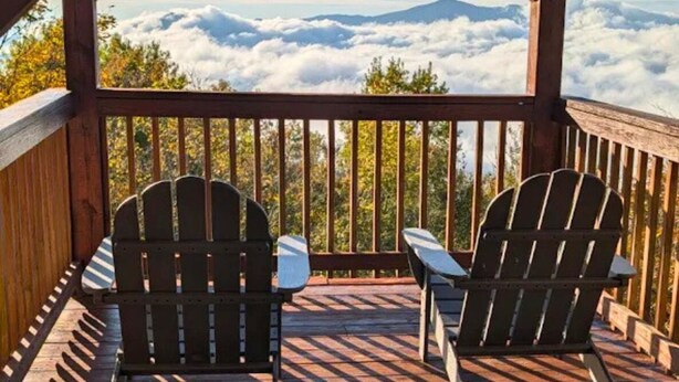 A wooden deck with Adirondack chairs overlooking a mountainous landscape. - Luxe | Ski-In/Out | Hot Tub | Panoramic Views | EV (Beech Mountain)