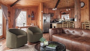 A wooden cabin interior with a living room, kitchen, and dining area. - Luxe | Ski-In/Out | Hot Tub | Panoramic Views | EV (Beech Mountain)