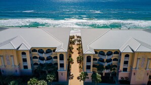 Un resort con un patio central, varios balcones y vista al océano.
