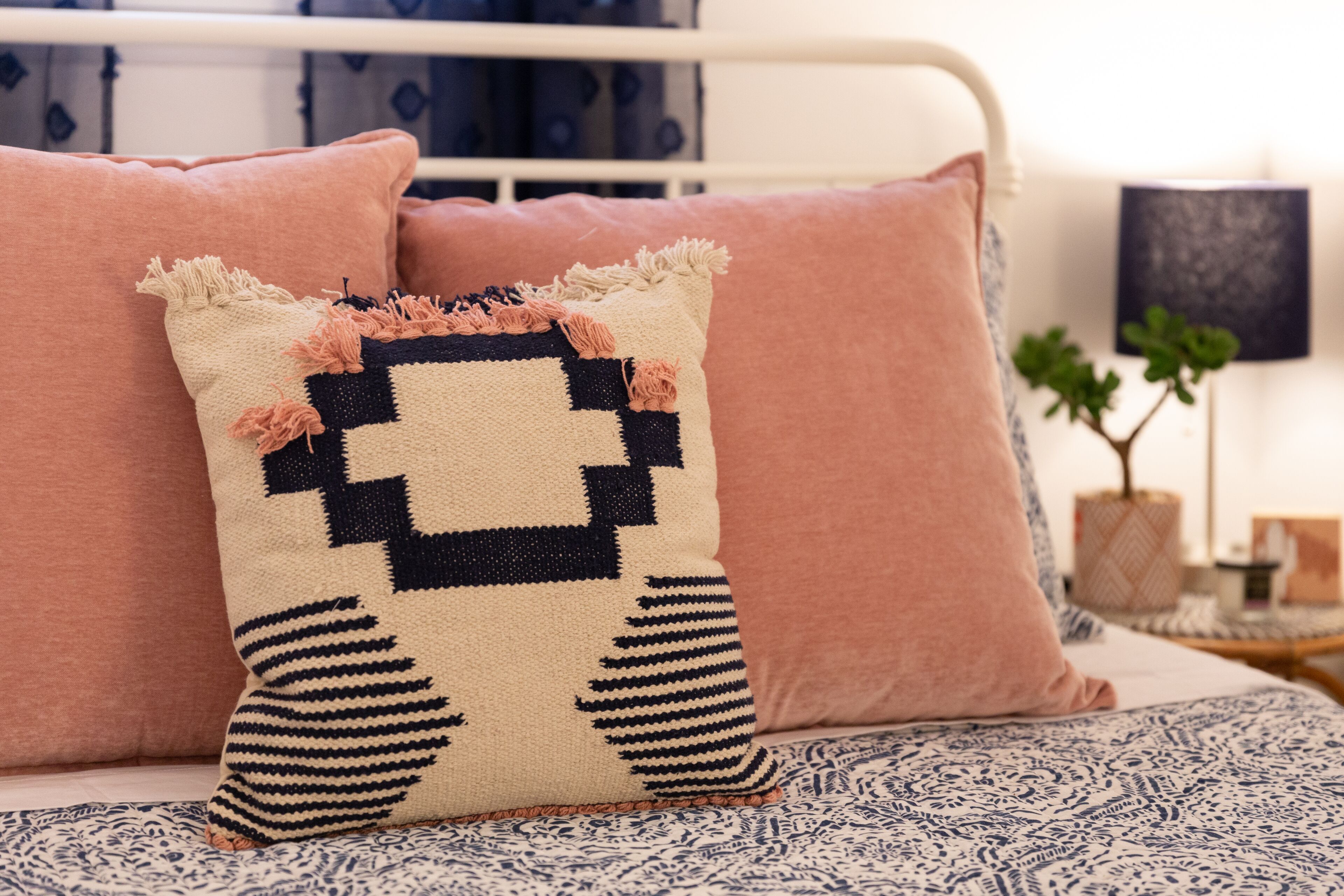 A bed with patterned bedding and a decorative pillow.