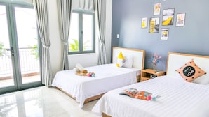 A hotel room with two beds, a large window with curtains, a nightstand, and wall art. - T P Luxury House (Da Nang)