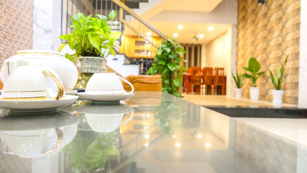 A modern interior with a reflective marble countertop displaying white teapots and cups. - T P Luxury House (Da Nang)