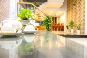 A modern interior with a reflective marble countertop displaying white teapots and cups. - T P Luxury House (Da Nang)