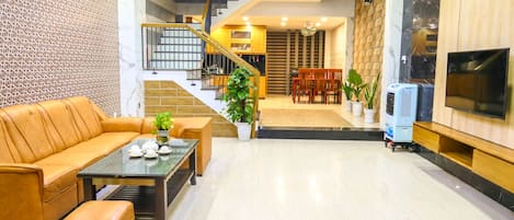 A modern living room with a sofa, coffee table, and a staircase leading to an upper floor.