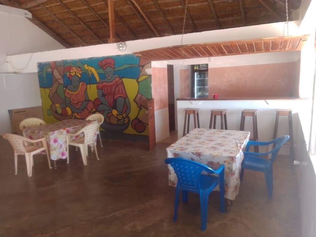 Zona pranzo con un murale, un bar e un angolo cottura.