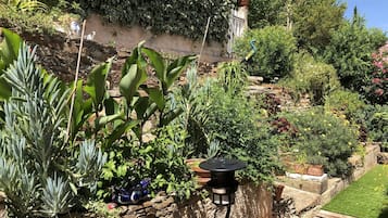 A garden with various plants and a decorative bird sculpture.