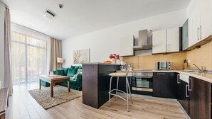Une cuisine moderne avec un îlot central, un coin repas avec un canapé et une grande fenêtre.