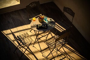 A dining table with a basket of bread, a glass of orange juice, and a cup of coffee. - LOFT VILLAGE HOUSE+AIR CONDITIONING+TERRACE, NEAR THE GOLF COURSE. (Vernègues)