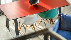 A modern dining area with a red table, colorful chairs, and a blue sofa. - LOFT VILLAGE HOUSE+AIR CONDITIONING+TERRACE, NEAR THE GOLF COURSE. (Vernègues)